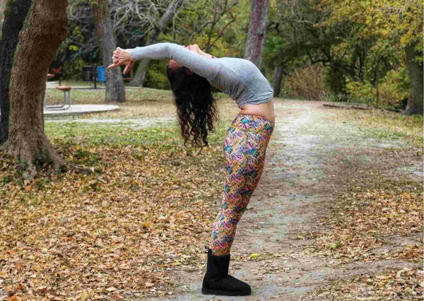 Girl wearing tropical print eco friendly yoga leggings in back bend pose